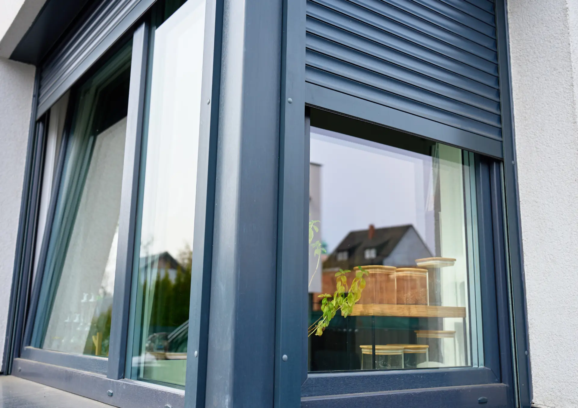 Fenêtres équipées de volets roulants anthracite sur une façade claire