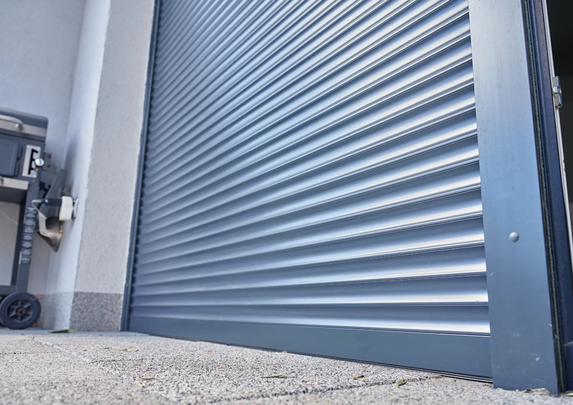 Porte de garage enroulable grise installée sur une maison